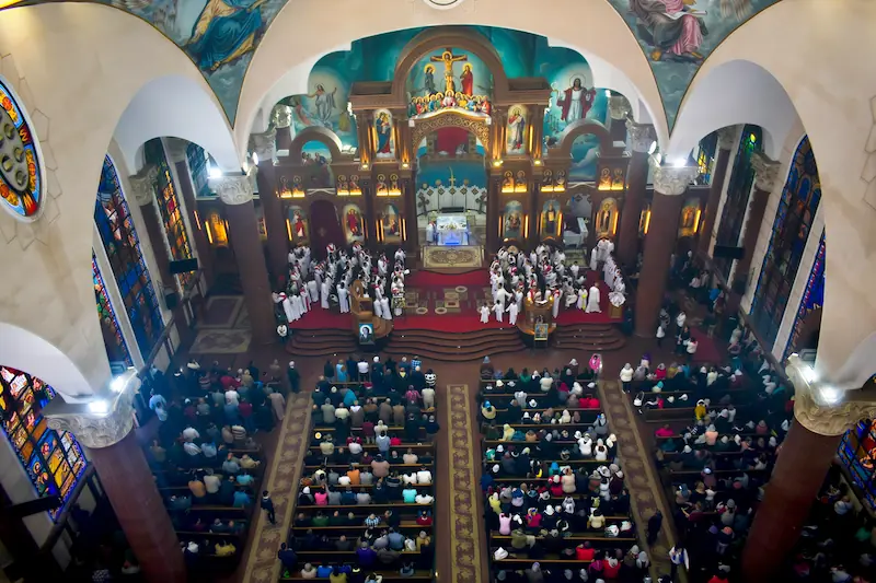 Coptic Orthodox cathedral interior — professional audio system transforming a highly reverberant domed sanctuary with marble surfaces into a clear worship environment